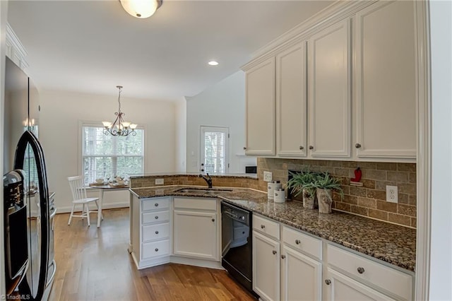 3001 Walbrook Ter, Browns Summit, NC 27214 - kitchen featuring black dishwasher, a sink, a chandelier, a peninsula, and light wood finished floors