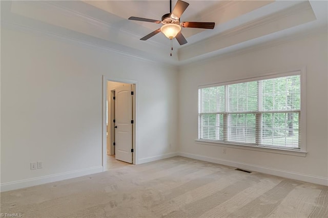 3001 Walbrook Ter, Browns Summit, NC 27214 - empty room featuring a raised ceiling, ornamental molding, healthy amount of natural light, a ceiling fan, and light colored carpet