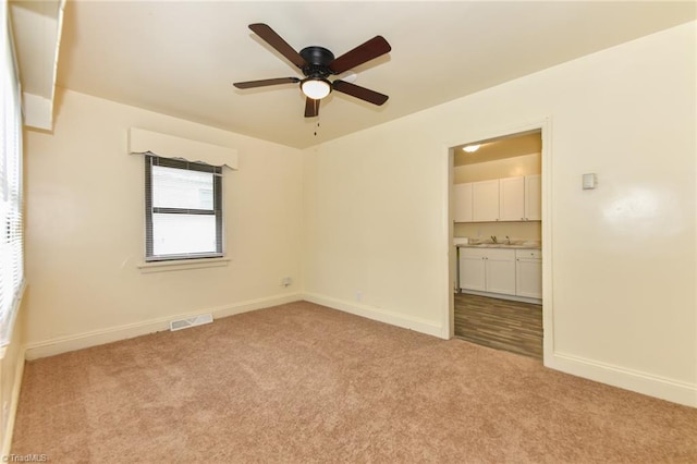 1017 Logan St Unit 2, Greensboro, NC 27406 - unfurnished room with light carpet, ceiling fan, baseboards, and a sink