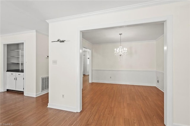 4548 Fernhaven Cir, Winston-Salem, NC 27104 - spare room featuring wood finished floors, a chandelier, crown molding, and baseboards