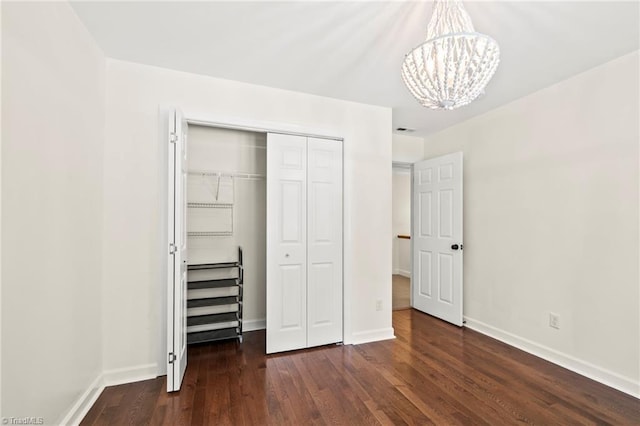 4548 Fernhaven Cir, Winston-Salem, NC 27104 - unfurnished bedroom with a chandelier, a closet, wood finished floors, and baseboards