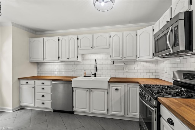 4548 Fernhaven Cir, Winston-Salem, NC 27104 - kitchen with butcher block countertops, appliances with stainless steel finishes, a sink, crown molding, and decorative backsplash
