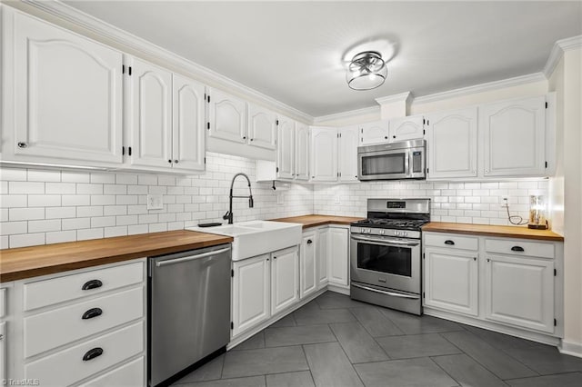 4548 Fernhaven Cir, Winston-Salem, NC 27104 - kitchen featuring stainless steel appliances, wood counters, a sink, white cabinets, and ornamental molding