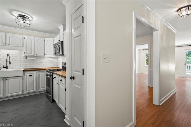 4548 Fernhaven Cir, Winston-Salem, NC 27104 - kitchen with stainless steel appliances, a sink, butcher block counters, ornamental molding, and decorative backsplash