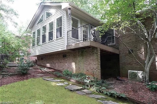 view of side of property with brick siding, a lawn, and an attached garage