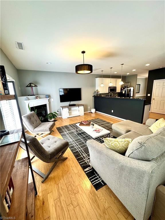 7213 Olmstead Dr, Burlington, NC 27215 - living room featuring light wood finished floors, a fireplace, recessed lighting, and baseboards