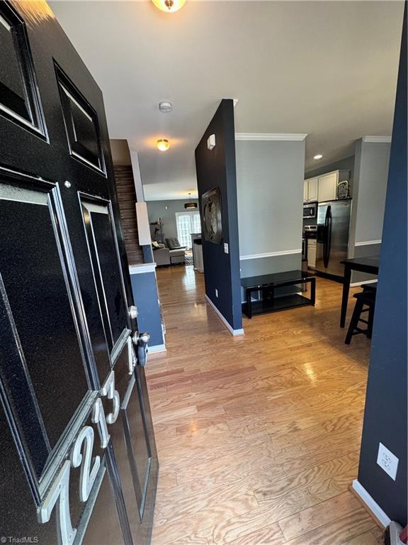 7213 Olmstead Dr, Burlington, NC 27215 - hall featuring ornamental molding, light wood-style floors, and baseboards