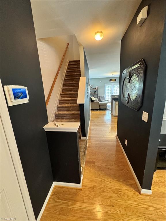 7213 Olmstead Dr, Burlington, NC 27215 - hallway featuring stairway, light wood finished floors, and baseboards
