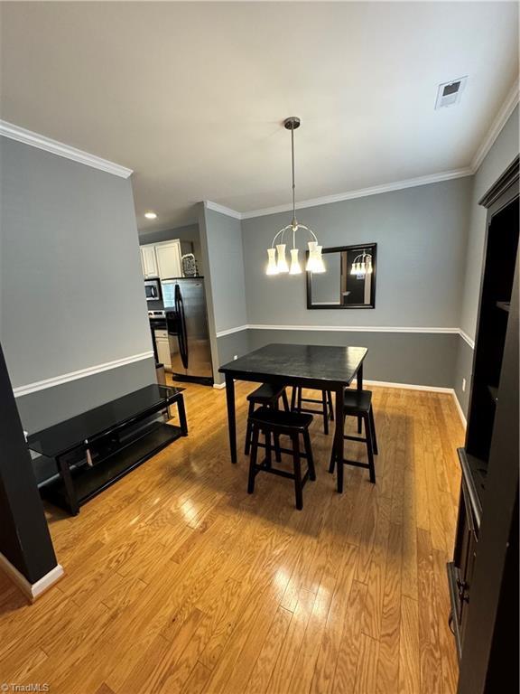 7213 Olmstead Dr, Burlington, NC 27215 - dining area featuring a chandelier, ornamental molding, light wood-style floors, baseboards, and recessed lighting