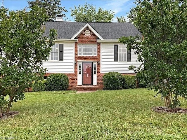 split foyer home with brick siding, a chimney, a shingled roof, a front yard, and entry steps