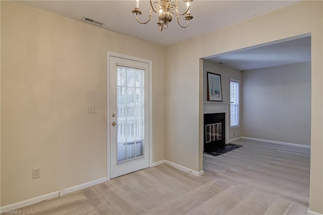 entryway featuring light carpet and a chandelier