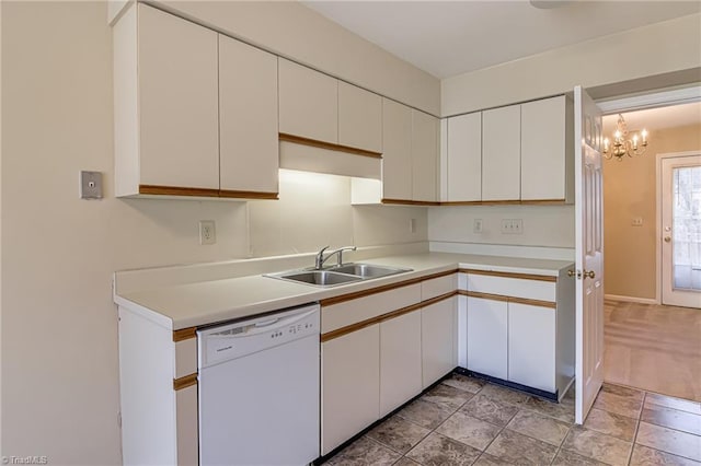 kitchen with white cabinetry, white dishwasher, sink, and a notable chandelier