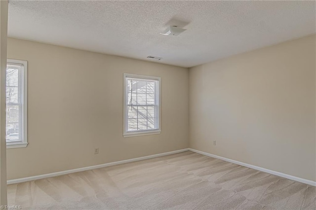 carpeted empty room with a textured ceiling