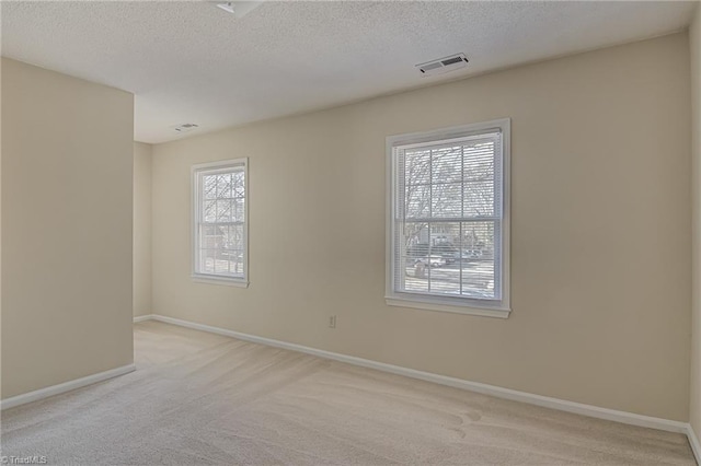 carpeted empty room featuring a textured ceiling