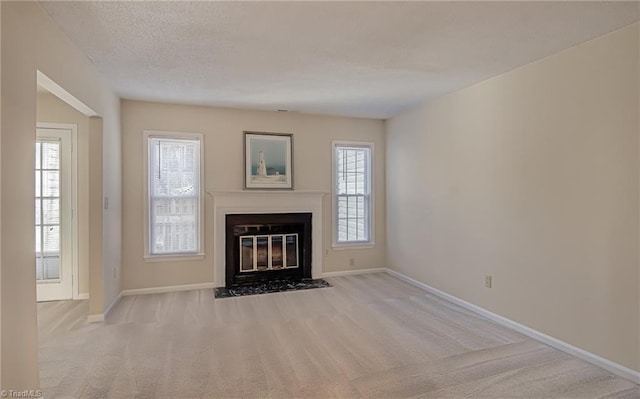 unfurnished living room with light colored carpet and a textured ceiling