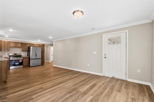 unfurnished living room featuring ornamental molding and wood-type flooring