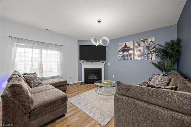 817 Sagemount St, Jamestown, NC 27282 - living area with light wood finished floors, a fireplace with flush hearth, and a chandelier