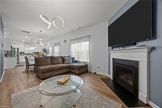817 Sagemount St, Jamestown, NC 27282 - living room with wood finished floors, a fireplace with raised hearth, baseboards, and recessed lighting