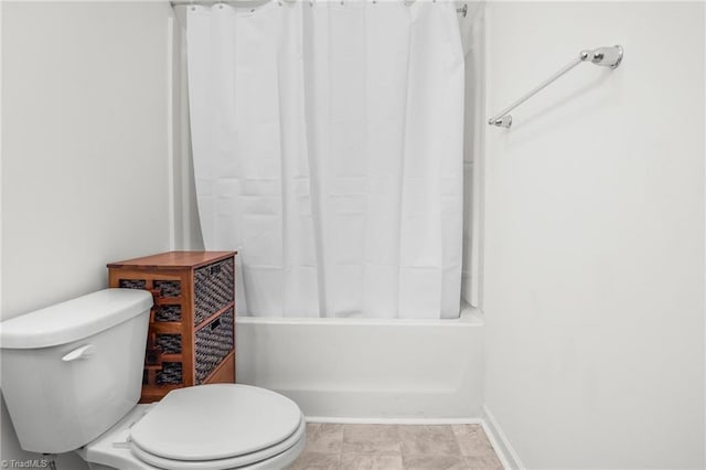 full bath featuring toilet and shower / tub combo with curtain