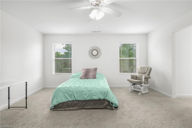 carpeted bedroom featuring multiple windows, baseboards, and ceiling fan