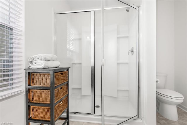 bathroom with a shower stall and toilet