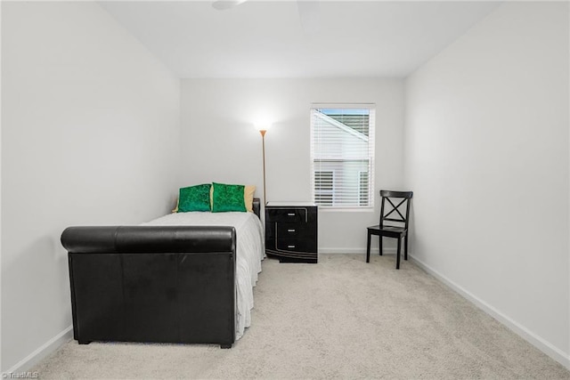 bedroom with light carpet and baseboards