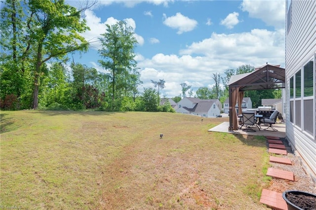 view of grassy yard with a gazebo and a patio