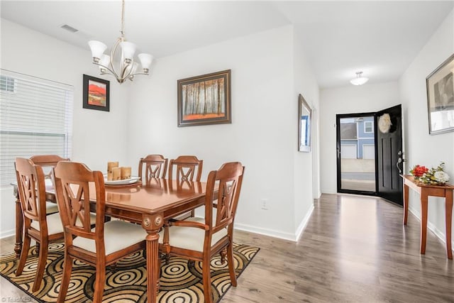 dining area with light wood finished floors, a chandelier, and baseboards
