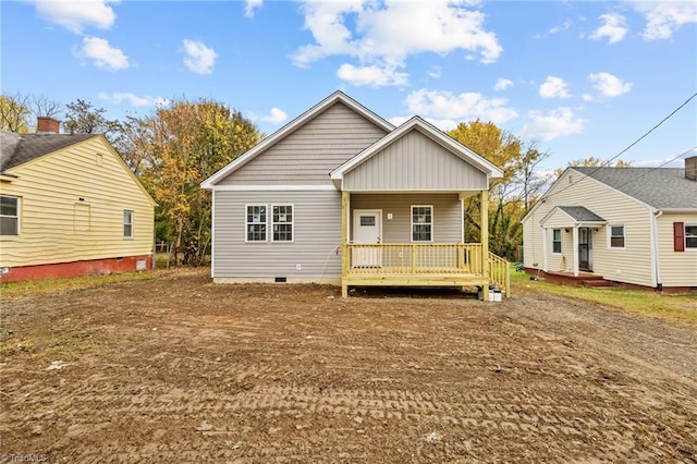 rear view of property featuring covered porch