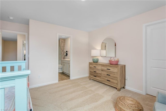 carpeted bedroom featuring connected bathroom and a nursery area