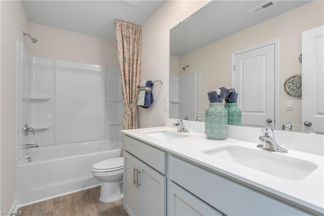 full bathroom featuring toilet, vanity, shower / bathtub combination, and wood-type flooring