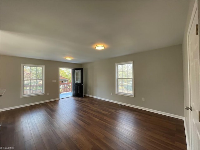 unfurnished room with dark hardwood / wood-style floors and a healthy amount of sunlight