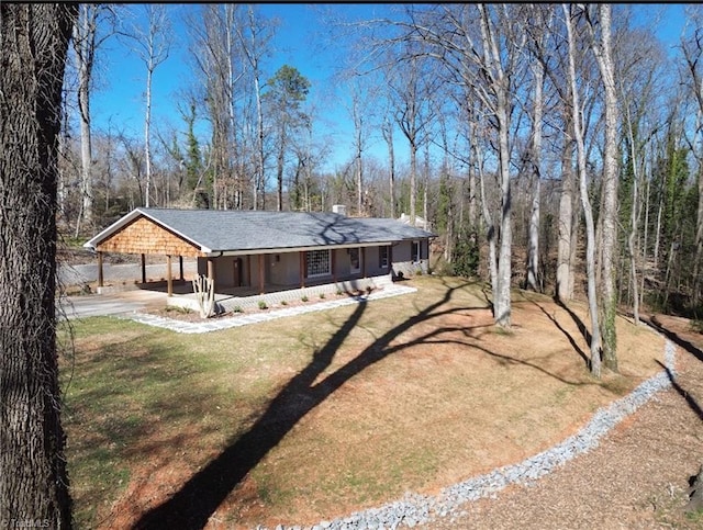 view of front of house featuring a carport, driveway, and a front lawn