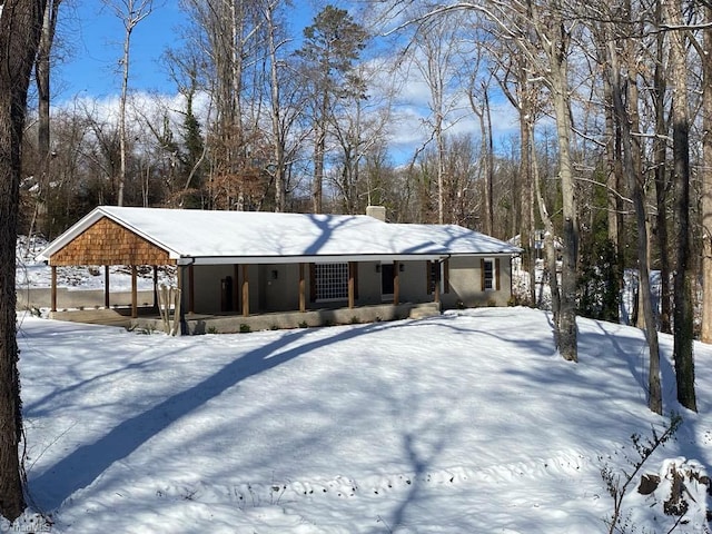 view of front facade with covered porch and a chimney