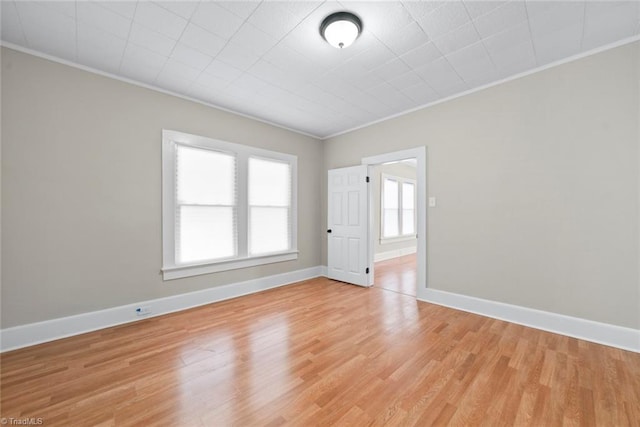 spare room featuring light hardwood / wood-style flooring and crown molding