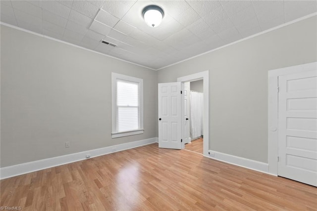 unfurnished room with ornamental molding and light hardwood / wood-style flooring