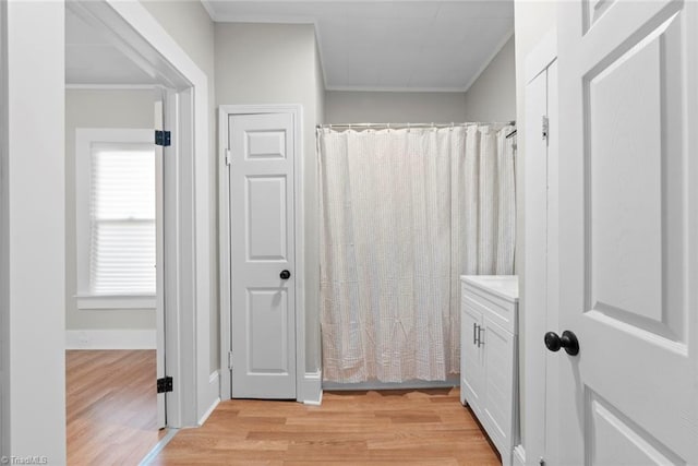 bathroom with hardwood / wood-style floors, a shower with curtain, vanity, and crown molding