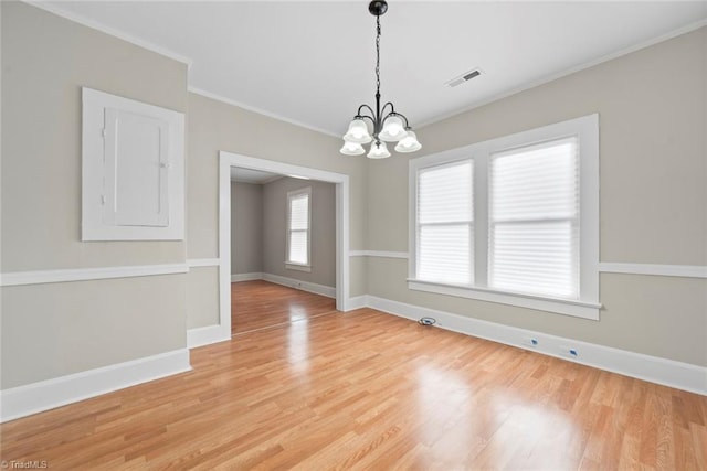 unfurnished room with light wood-type flooring, a chandelier, and crown molding