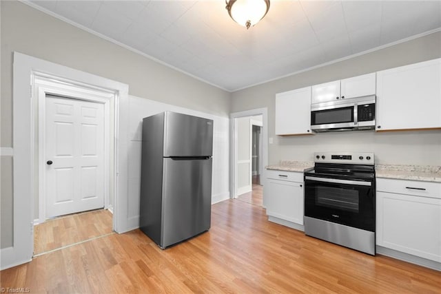 kitchen featuring light wood-type flooring, white cabinetry, crown molding, and stainless steel appliances