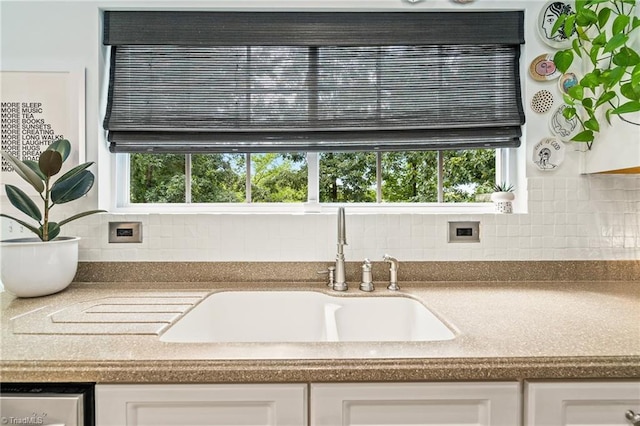 room details with a sink, white cabinets, and tasteful backsplash