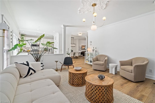 living area featuring ornamental molding, wood finished floors, baseboards, recessed lighting, and a notable chandelier