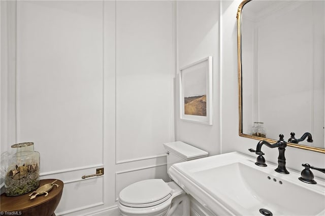 half bathroom featuring a sink and toilet