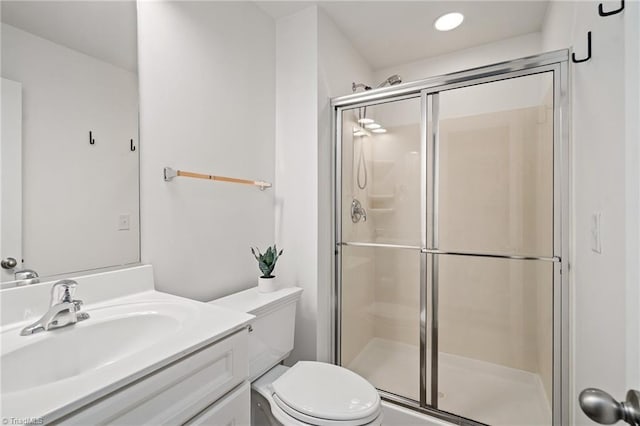 full bathroom featuring vanity, toilet, and a shower stall
