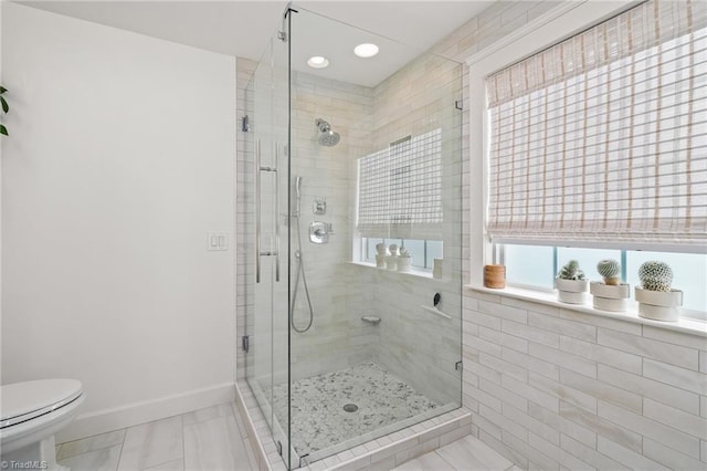 full bathroom with baseboards, a stall shower, and toilet