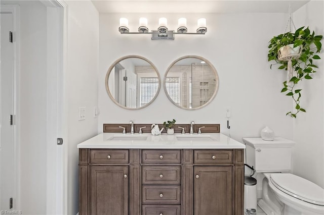 full bath with double vanity, toilet, and a sink