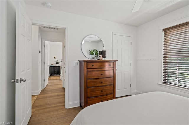 bedroom with visible vents, baseboards, and wood finished floors