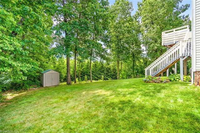 view of yard featuring a storage shed, an outbuilding, and stairway