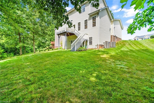 back of property with a lawn, a deck, central AC, and stairway