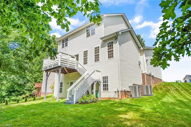 rear view of house with central air condition unit, a lawn, stairs, and a deck