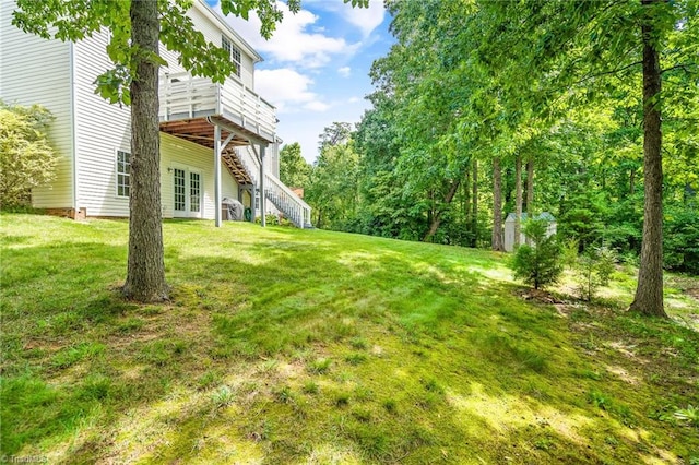 view of yard featuring stairs, a wooden deck, and french doors